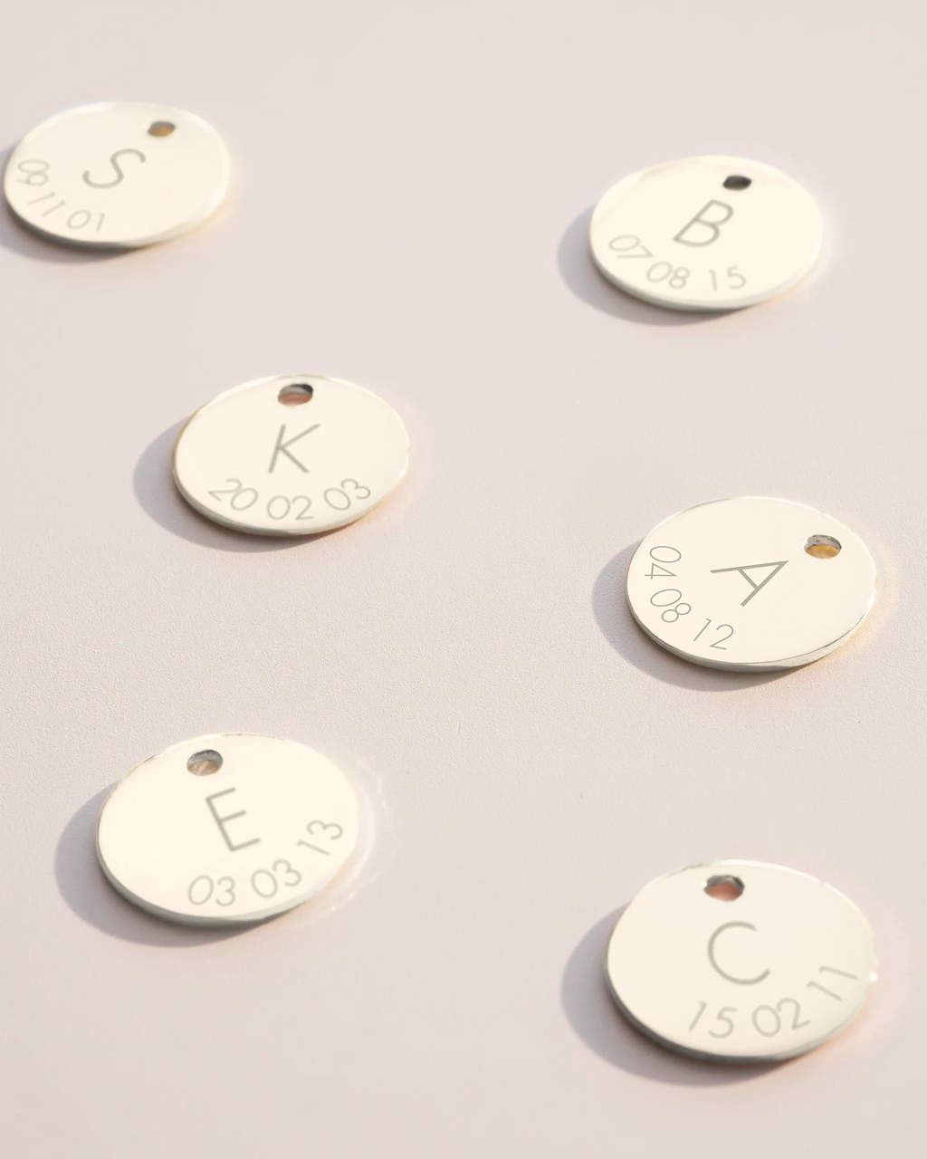 Silver disc charms with initial and date engravings
