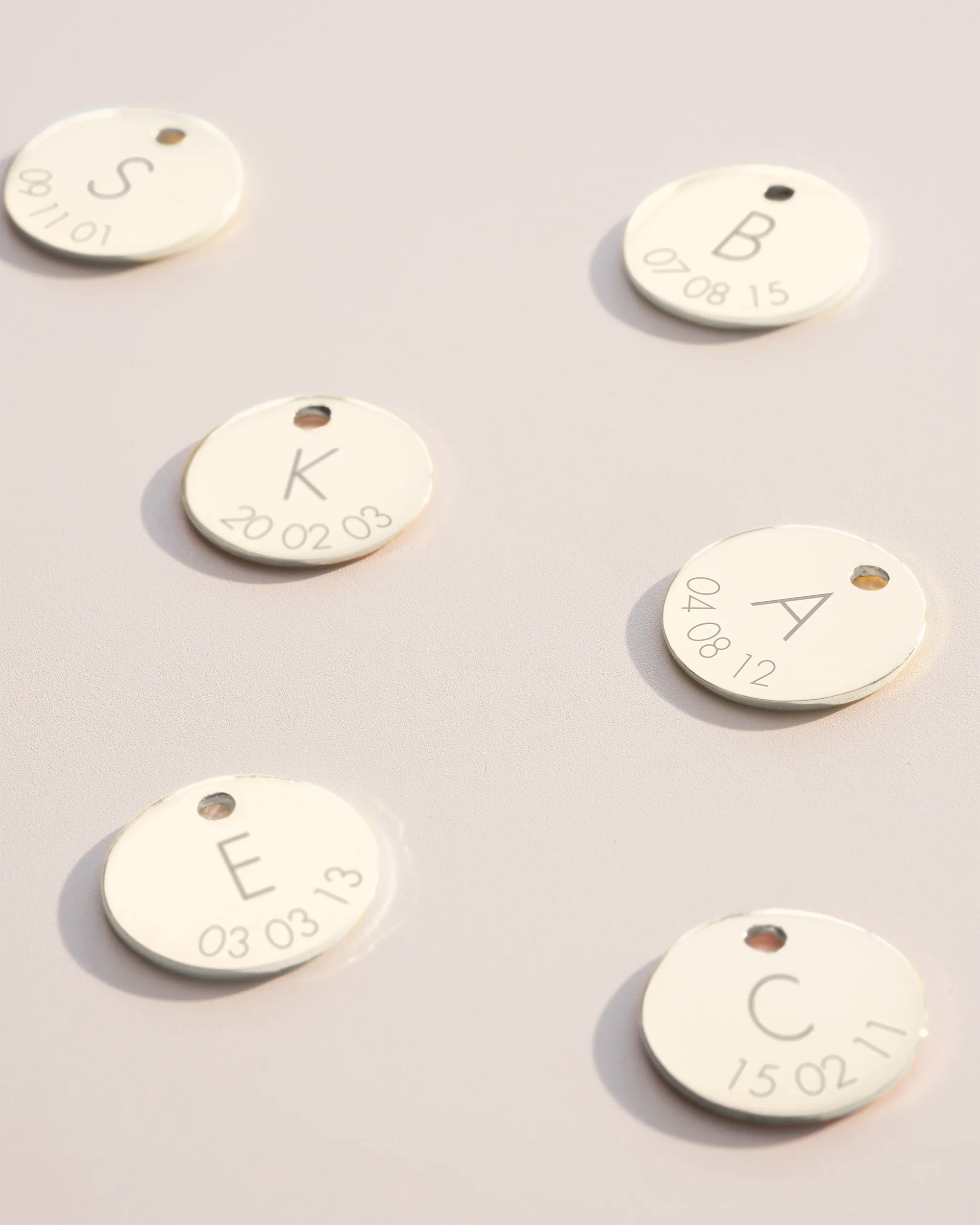 Silver disc charms with initial and date engravings