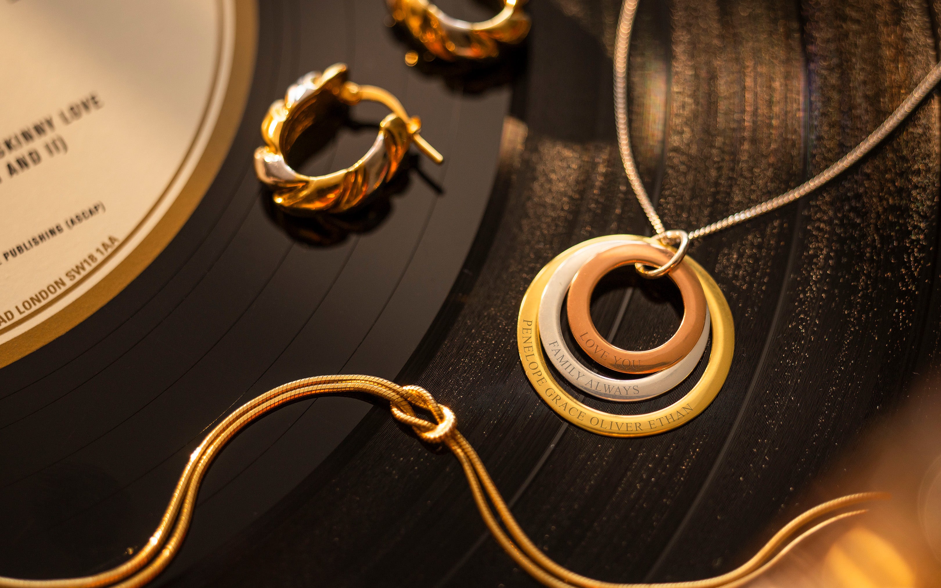 Gold jewelry including a necklace and earrings on a dark surface
