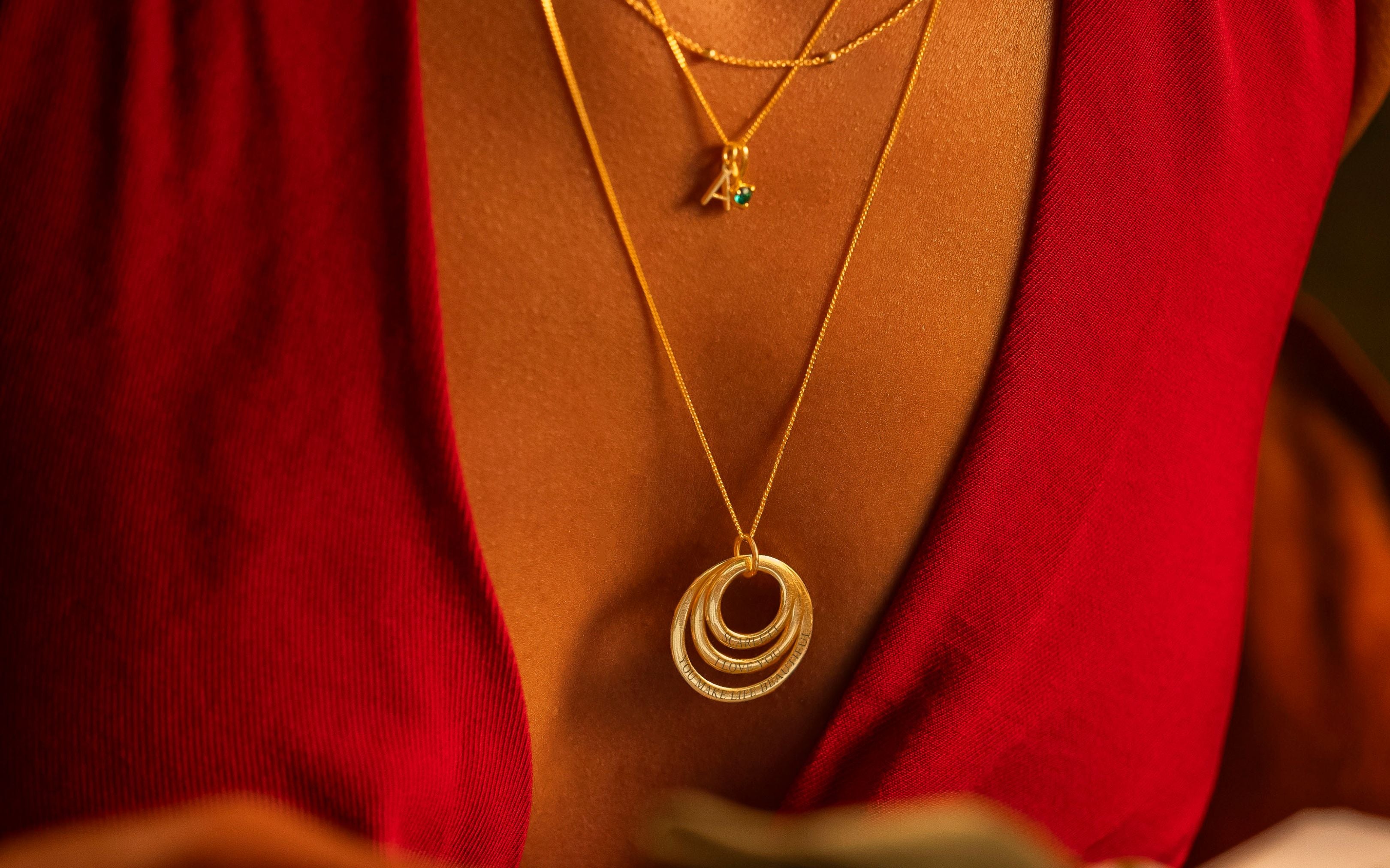 Gold necklaces on a person wearing a red garment