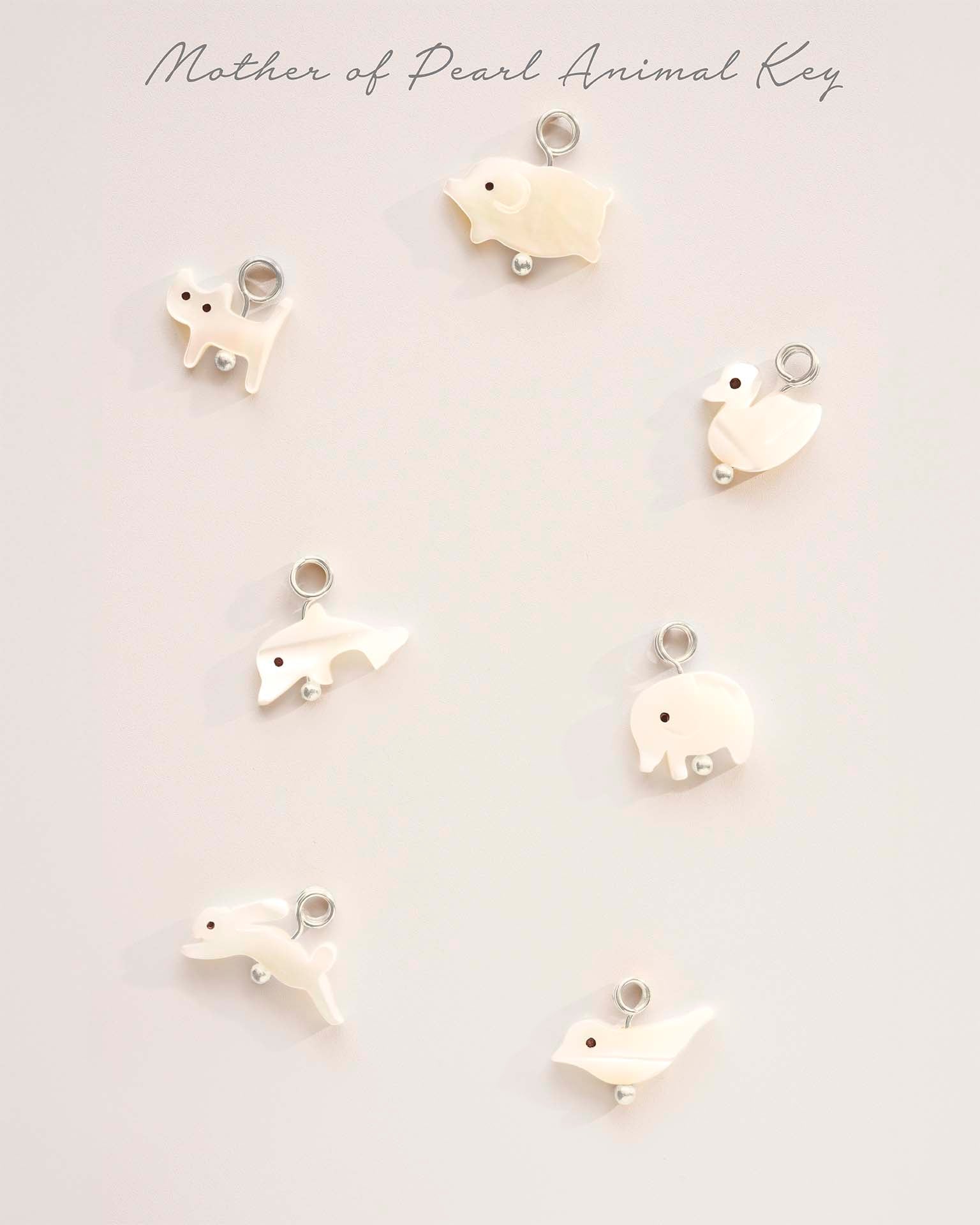 Set of white animal-shaped keychains on a light gray background