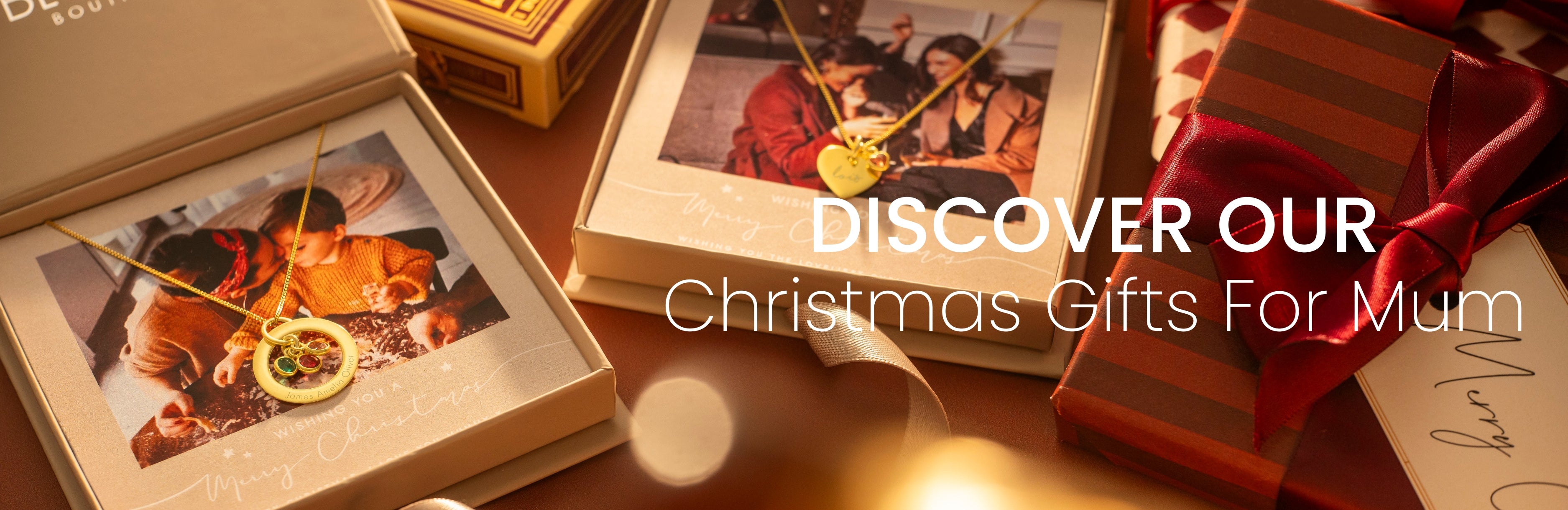 Christmas gift set with photo album, wrapped gift, and red ribbon on a wooden surface.