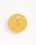 Gold disc charm with letter 'S' and numbers '08 11 95' on a white background