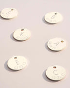 Gold tags with engraved letters and dates on a light gray background