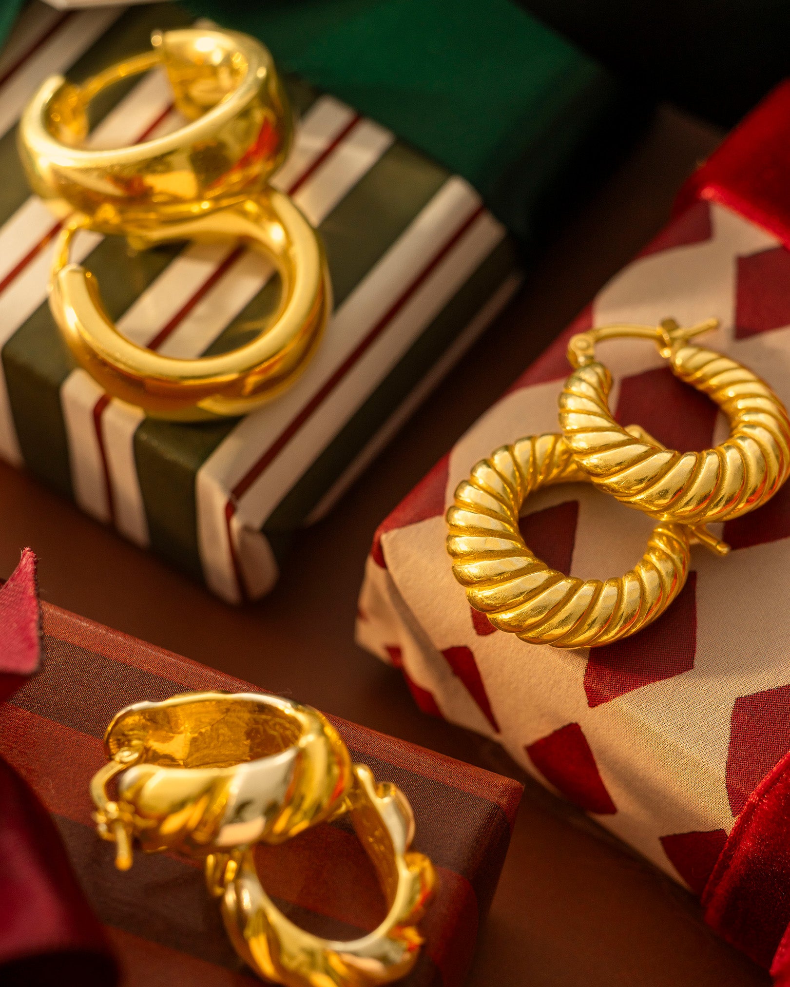 Gold hoop earrings on a decorative box with a festive background